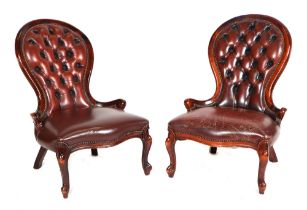 A pair of Victorian-style leather upholstered button back chairs.