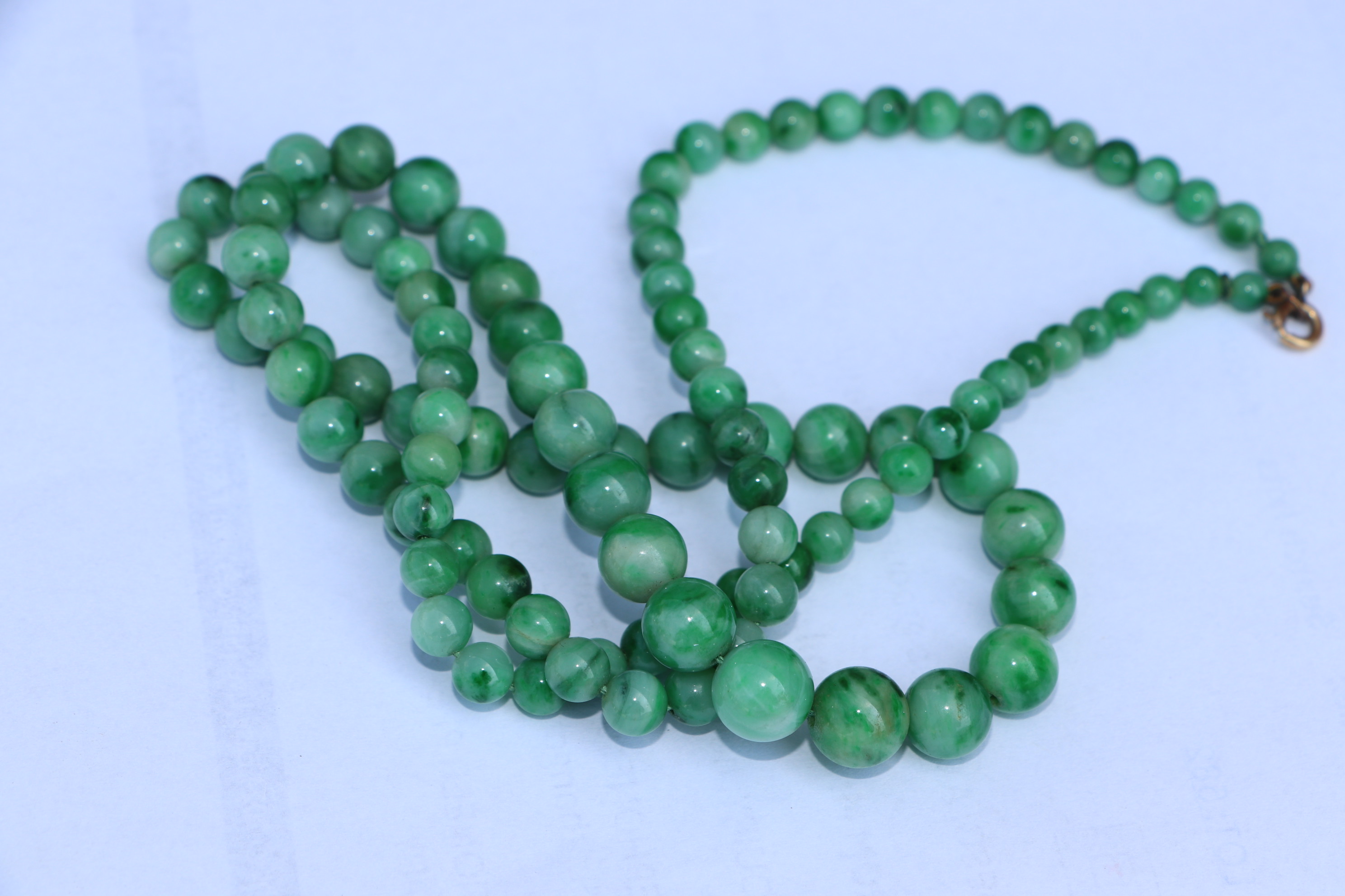 A Chinese graduated apple jade bead necklace, approx 64cm long. Condition Report A crack to one - Image 4 of 7