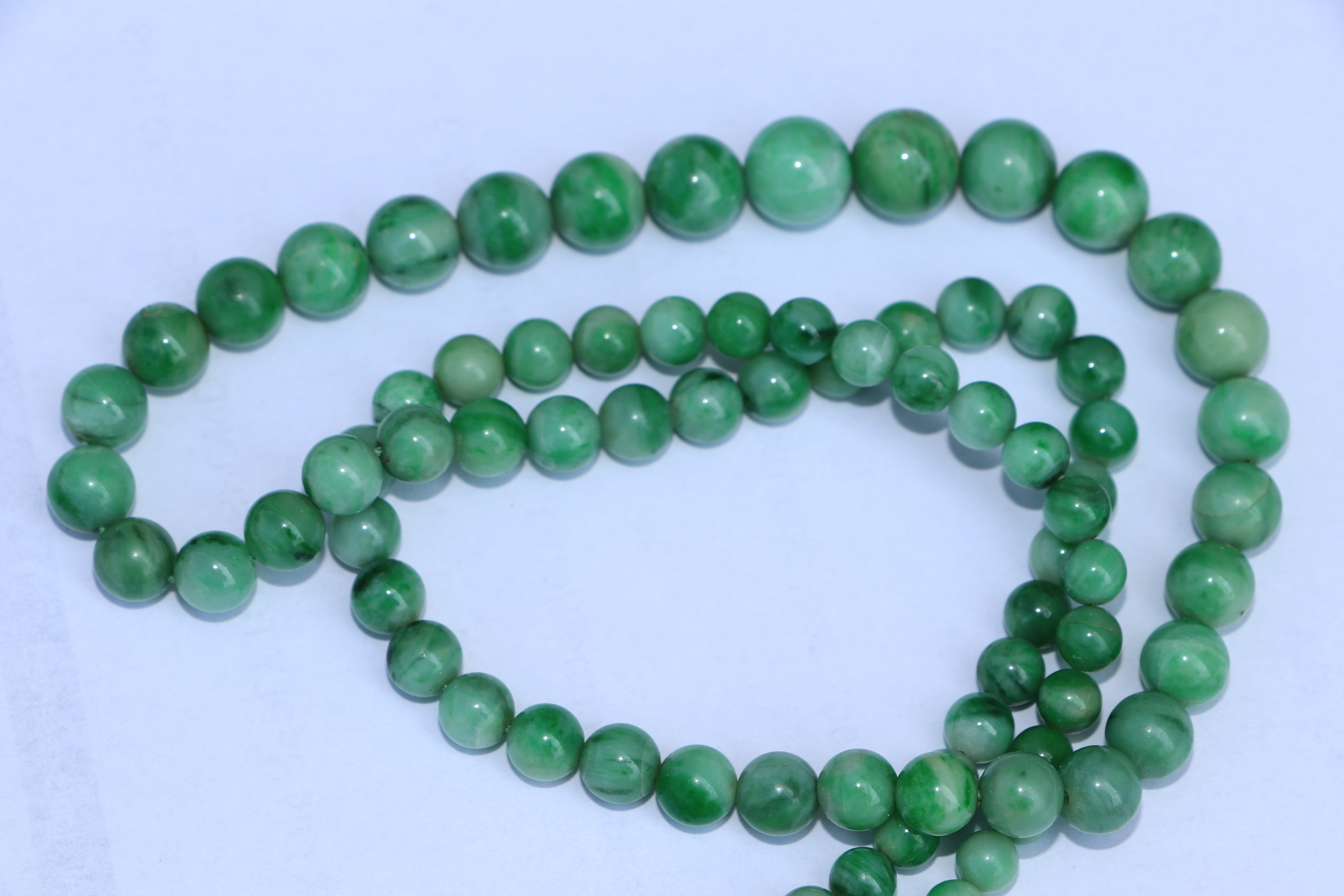 A Chinese graduated apple jade bead necklace, approx 64cm long. Condition Report A crack to one - Image 6 of 7