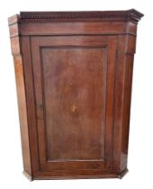 A 19th century mahogany hanging corner cabinet, having field panel door enclosing shelves, 86cm