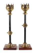 A pair of gothic revival brass and iron candle sticks, on oak bases, 63cm high (2).
