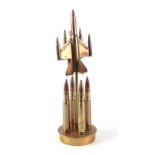 A trench art cast brass model of a Jet aircraft, constructed from brass bullets, mounted on a