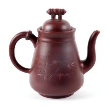 A Chinese Yixing pottery teapot decorated with bamboo, four character mark to the underside, 16cm