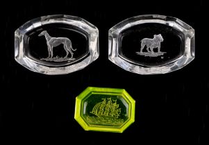 A pair of baccarat intaglio pin dishes, decorated dogs, 10cm wide, together with another yellow