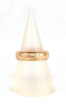 An 18ct gold wedding band with engraved decoration, approx UK size J, 3.8g.