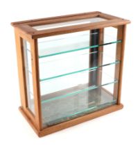 An oak framed table top glass display cabinet, with four internal glass shelves, 39cm wide.