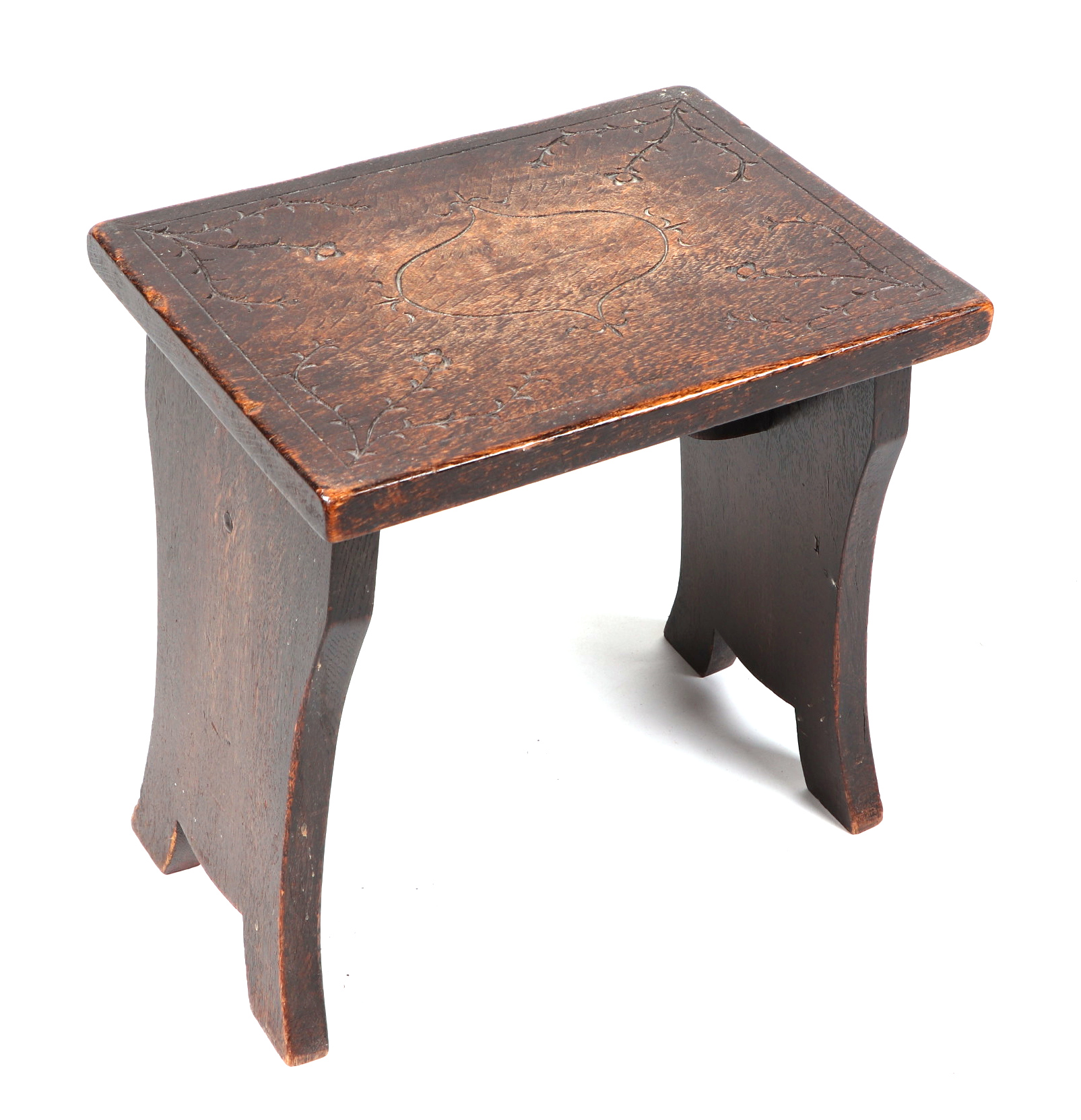 A small oak stool, with carved top, 34cm wide, together with a three tier mahogany wall shelf,