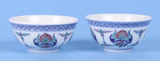 A pair of Chinese Wucai style tea bowls decorated with flowers, six character blue mark to the