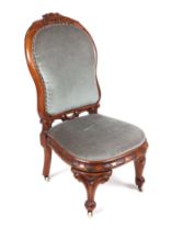 A Victorian walnut nursing chair, with upholstered seat and back.