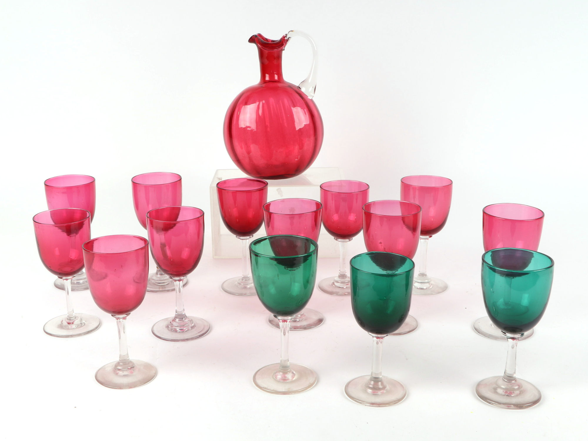 A set of 12 cranberry glass wine glasses, with matching carafe, a celery vase, a pair of spiral