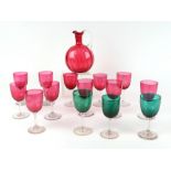 A set of 12 cranberry glass wine glasses, with matching carafe, a celery vase, a pair of spiral