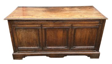 A 18th century style oak coffer of large proportions, having a three panel front standing on bracket