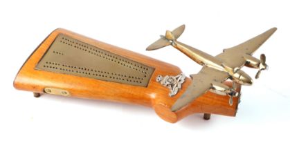 A trench art cast brass model of a Mosquito aircraft, mounted on a riffle butt inset a brass