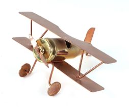A trench art cast brass and copper model of a bi-plane, constructed from a large brass bullet,