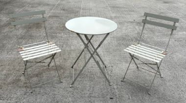 A painted metal bistro set, consisting of circular table and two chairs.