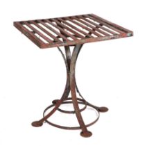 A well weathered heavy iron strap work garden table, the square top on four supports, joined by