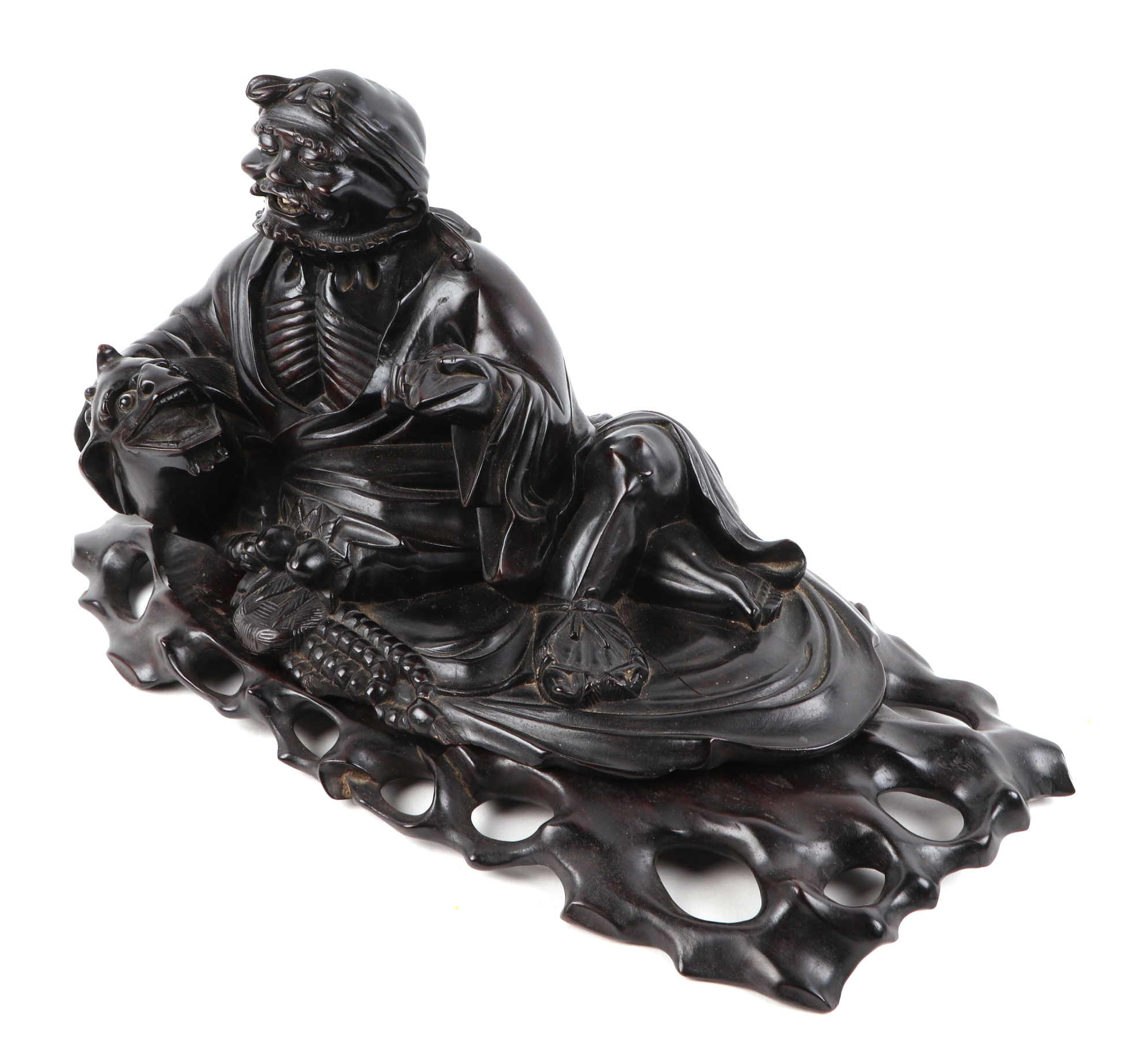 A Chinese hardwood figure, of a recumbent bearded man holding a bat seated beside a temple lion, - Image 2 of 3