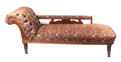 A Victorian upholstered chaise long, having carved show wood and turned legs.