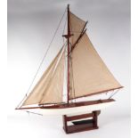 A pond yacht, having a painted hull, 72cm long, mounted on a stand. Condition Report Looks to be