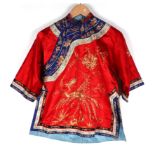 A Chinese silk short jacket decorated with embroidered bullion wire phoenix and flowers, on a red