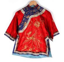 A Chinese silk short jacket decorated with embroidered bullion wire phoenix and flowers, on a red
