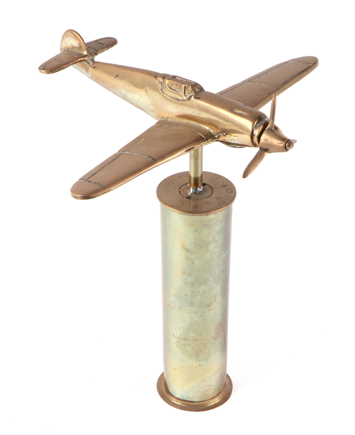 A trench art cast brass model of a Messerschmitt BF110, mounted on a brass shell case, wingspan