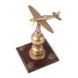 A trench art cast brass model of a Spitfire, mounted on a brass and Bakelite plinth, wingspan 11cm.