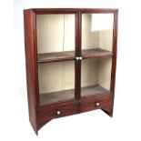 A teak display cabinet, having twin glazed doors enclosing shelves, above a drawer, 86cm wide.