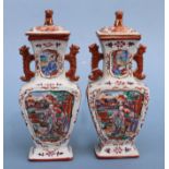 A pair of Chinese Mandarin palette famille rose Export vases and covers moulded in relief with