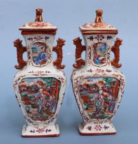 A pair of Chinese Mandarin palette famille rose Export vases and covers moulded in relief with