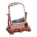 A Victorian mahogany toilet mirror, having an arch rectangular plate, on scroll supports, and