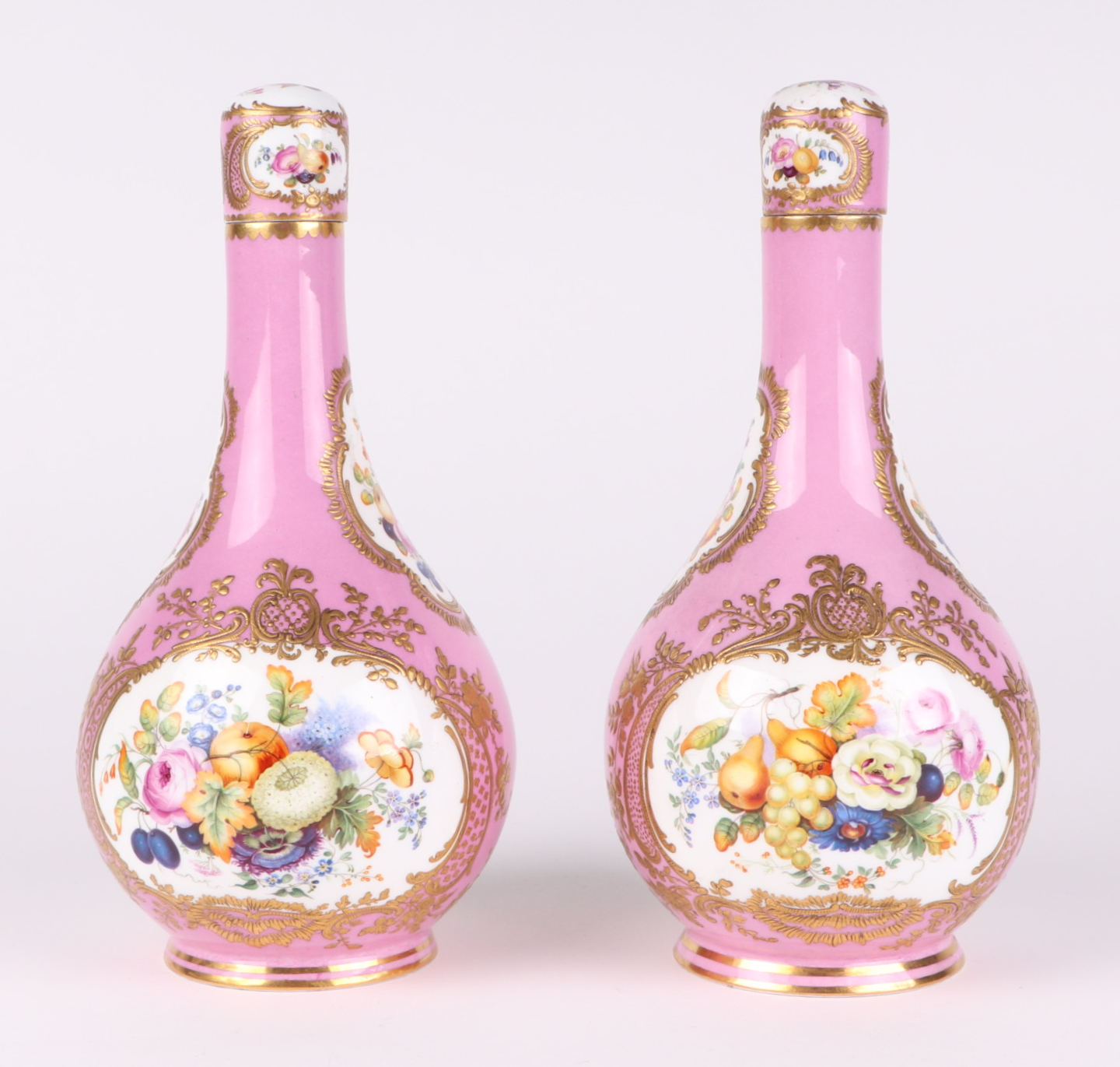 A pair of 19th century Sevres bottle vases and stoppers decorated with sprays of flowers within gilt