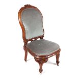 A Victorian walnut nursing chair, with upholstered seat and back.