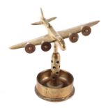 A trench art cast brass model of a Sterling aircraft, mounted on a brass shell case, wingspan 19cm.