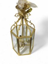 A modern brass lantern style light fitting, with b