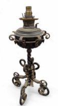 A wrought iron oil lamp, decorated with leaves and