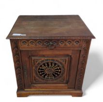 A square stained oak cupboard, the single carved d