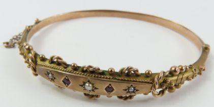 An early 20th century 9ct gold hinged bangle, the