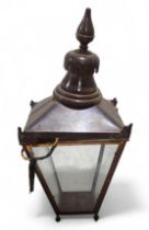 A copper outdoor lantern light fitting, with four