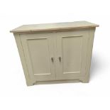 A cream cupboard with an unfinished pine top, the