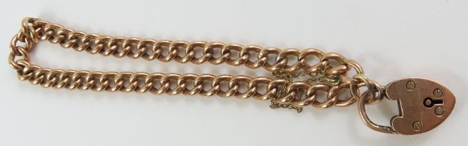 A rose gold curb link bracelet, with a heart padlo