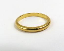 A wedding band, marked '22ct', finger size M 1/2,
