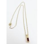 A contemporary garnet pendant, 1.5cm long, tests a