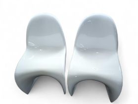 A pair of white plastic moulded chairs