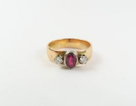 A ruby and diamond three stone ring, the oval shap