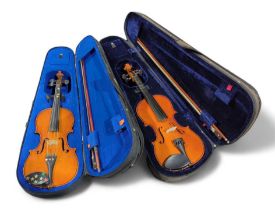 Two cased violins each with a bow (2)