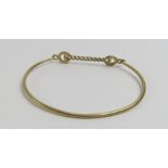 A 9ct gold bangle with a chain link fastening to t