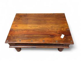 An Oriental hardwood coffee table with inset metal