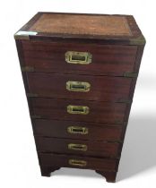 A narrow chest of six drawers with inset brass han