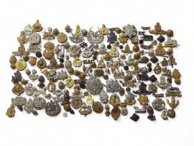 A collection of military cap badges, many differen